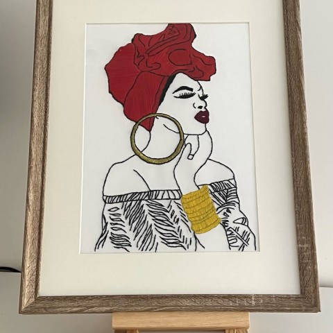 Embroidered painting of an Overseas Woman named Gisèle, showcased in a natural wooden frame.